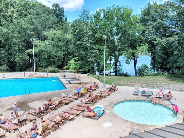 view of pool with a patio area and a diving board