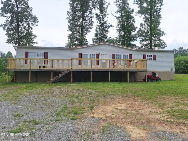 rear view of property featuring a wooden deck and a yard