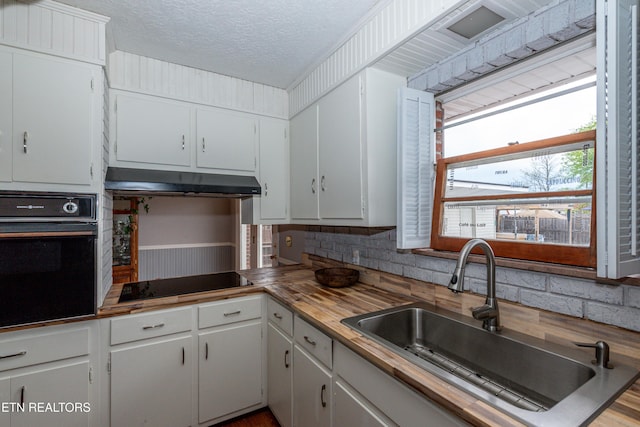 kitchen featuring sink, white cabinets, and black appliances