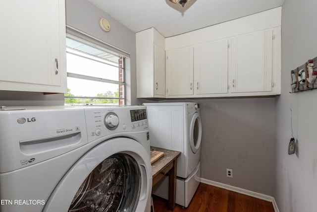 laundry room with dark hardwood / wood-style flooring, cabinets, and washer and clothes dryer