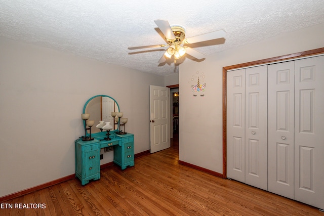 unfurnished bedroom featuring ceiling fan, light hardwood / wood-style floors, a closet, and a textured ceiling