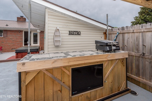 view of patio / terrace featuring a hot tub and a grill