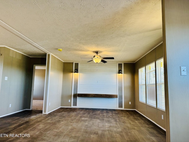 unfurnished room featuring a ceiling fan, dark wood-style floors, and a textured ceiling