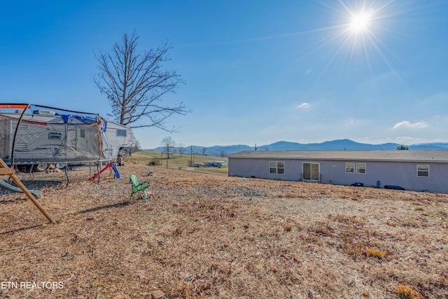 view of yard featuring a mountain view and a trampoline