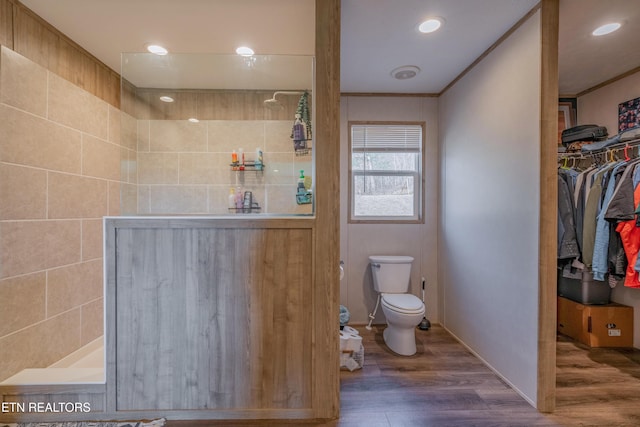 full bathroom featuring wood finished floors, recessed lighting, a walk in shower, crown molding, and toilet