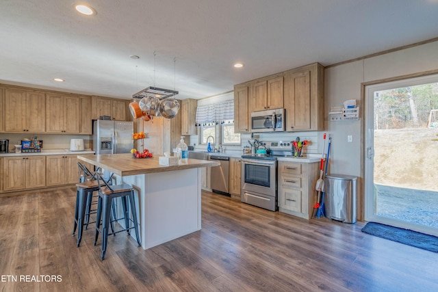 kitchen featuring light countertops, dark wood-style floors, appliances with stainless steel finishes, and a center island