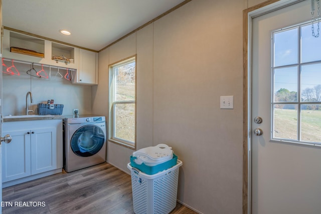 laundry room featuring wood finished floors, washer / clothes dryer, cabinet space, recessed lighting, and a sink