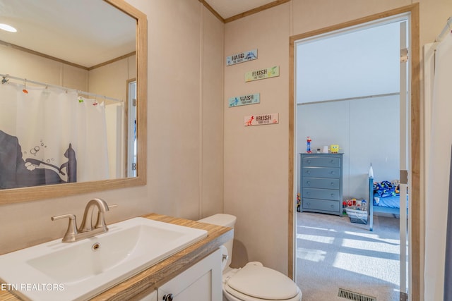 bathroom featuring vanity, crown molding, toilet, and visible vents