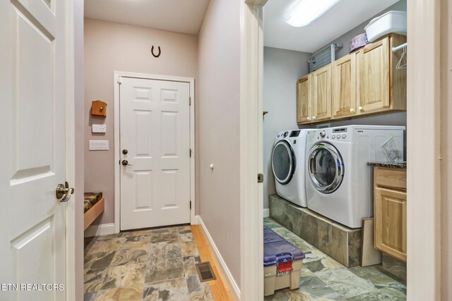 laundry room featuring cabinets and washer and dryer