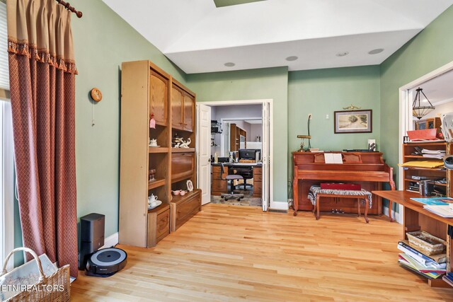 miscellaneous room featuring light wood-type flooring and vaulted ceiling