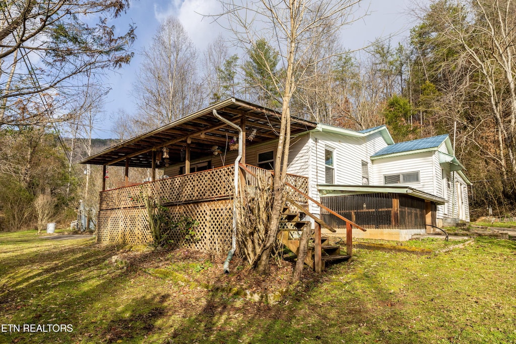 rear view of property featuring a lawn and a sunroom