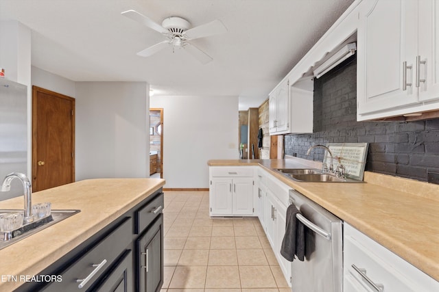 kitchen with stainless steel dishwasher, ceiling fan, sink, light tile patterned floors, and white cabinetry