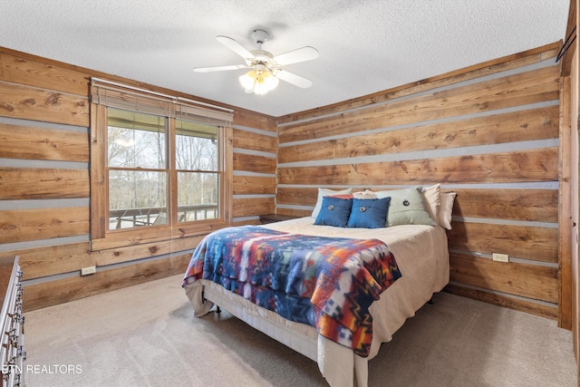 carpeted bedroom with a textured ceiling, ceiling fan, and wooden walls