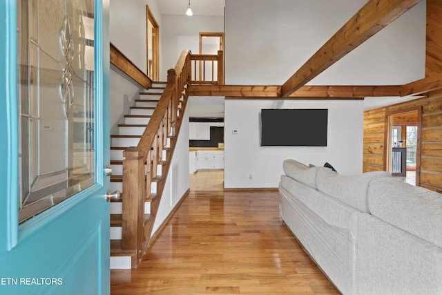 living room with beamed ceiling and light hardwood / wood-style floors