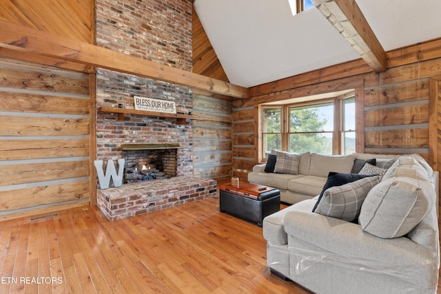 living room featuring beam ceiling, a fireplace, high vaulted ceiling, and hardwood / wood-style floors