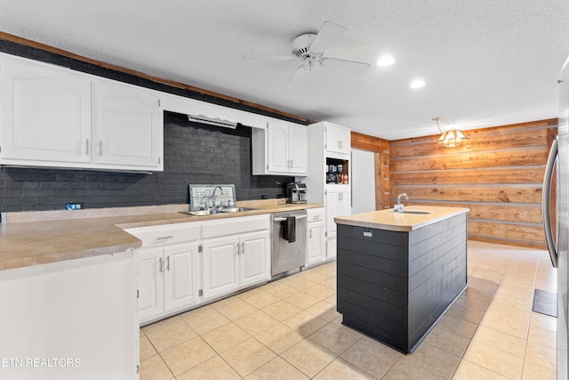 kitchen with white cabinetry, sink, stainless steel dishwasher, a textured ceiling, and a center island with sink