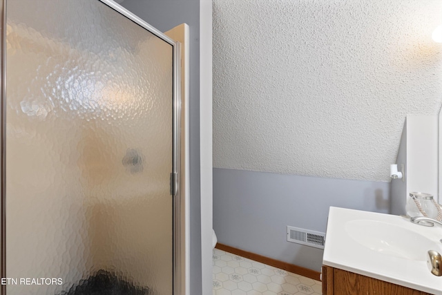 bathroom with vanity, walk in shower, and lofted ceiling