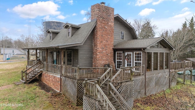 rear view of house with a sunroom and a porch