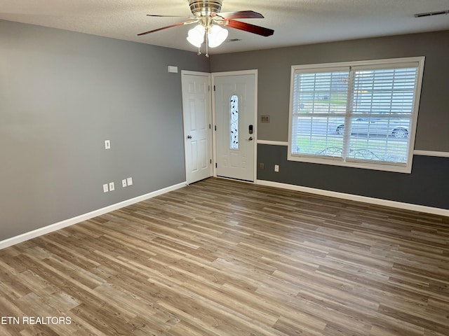 interior space with a textured ceiling, light hardwood / wood-style flooring, and ceiling fan