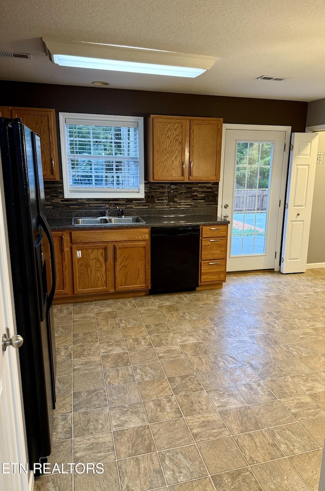 kitchen with black appliances, a textured ceiling, sink, and tasteful backsplash