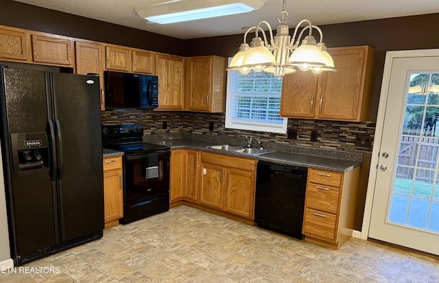 kitchen featuring tasteful backsplash, sink, black appliances, pendant lighting, and a chandelier