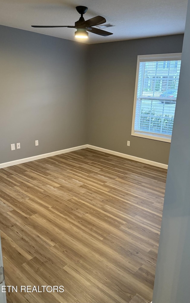 empty room with ceiling fan and hardwood / wood-style floors