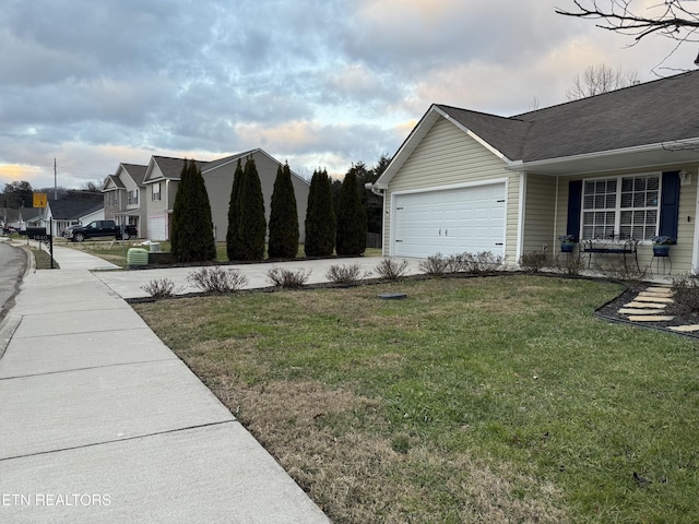 view of side of property with a lawn and a garage