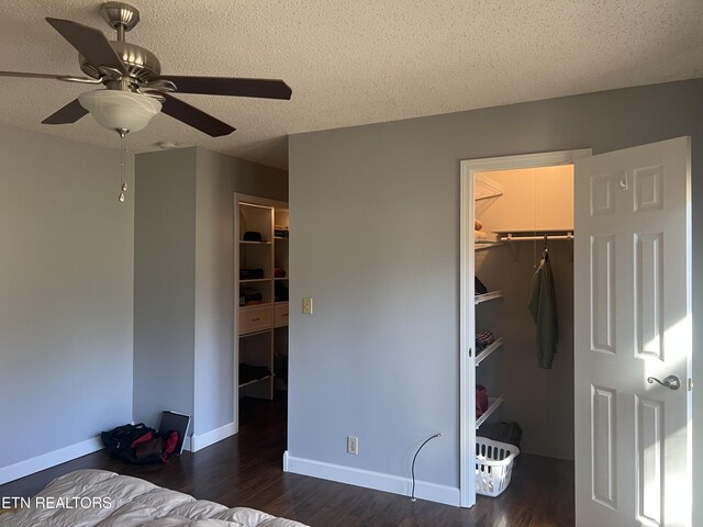 unfurnished bedroom with ceiling fan, a spacious closet, a textured ceiling, and a closet