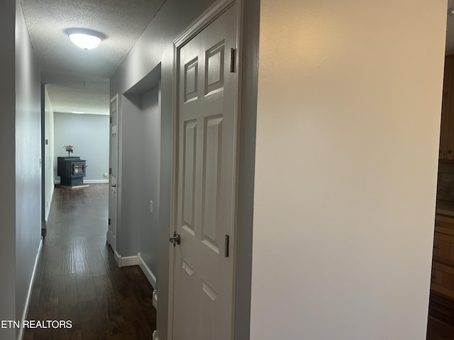 corridor featuring dark hardwood / wood-style flooring and a textured ceiling