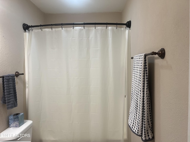 bathroom with toilet and curtained shower