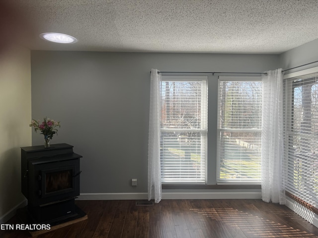 interior space featuring a textured ceiling and a wood stove