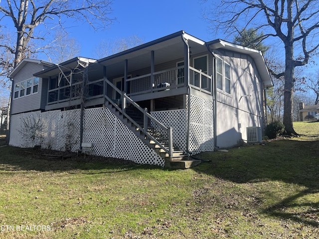 back of property featuring central AC and a yard