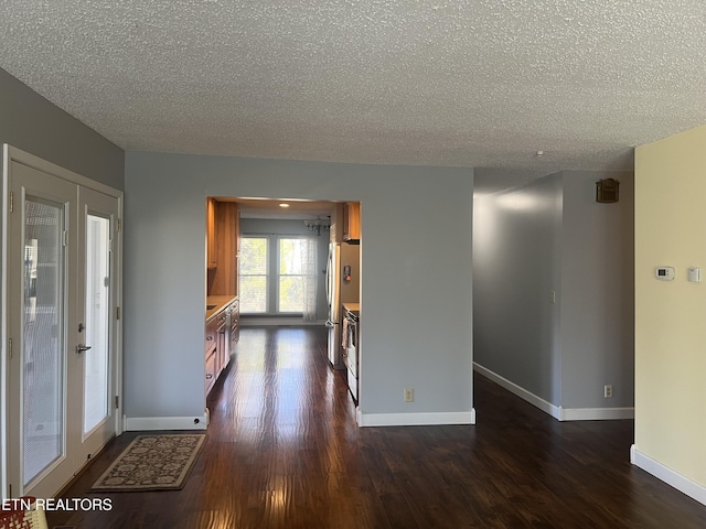 empty room with a textured ceiling, french doors, and dark hardwood / wood-style floors