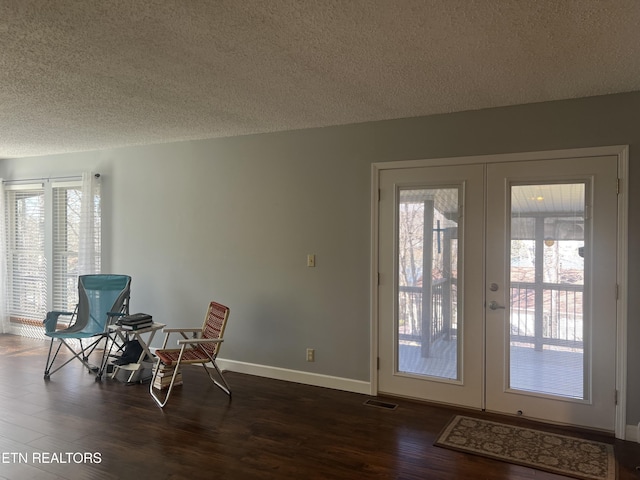 interior space with dark hardwood / wood-style floors, a textured ceiling, and french doors