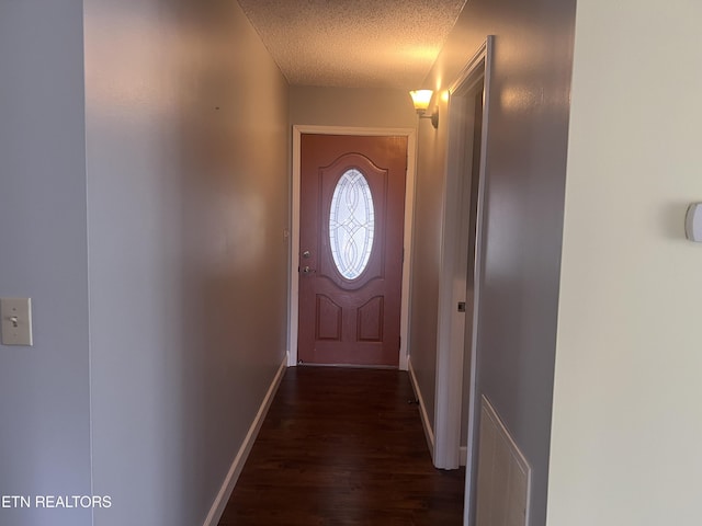 entryway featuring dark hardwood / wood-style flooring and a textured ceiling