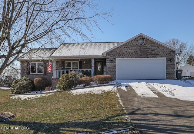 ranch-style home featuring a porch, a front yard, and a garage