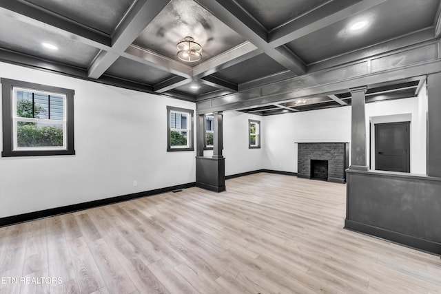 basement featuring a stone fireplace and light hardwood / wood-style flooring