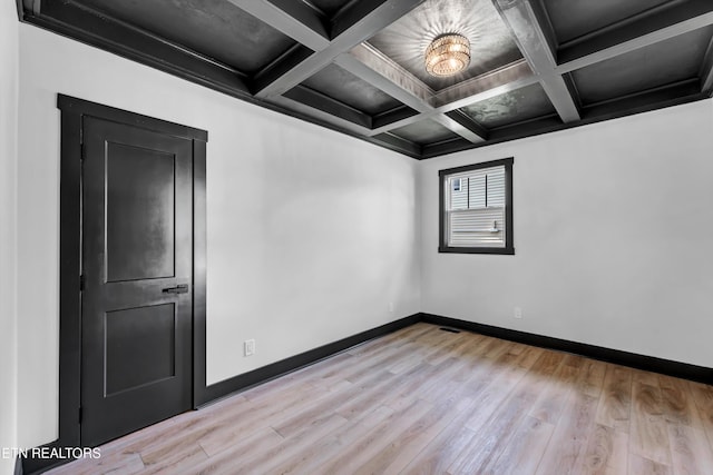 empty room with beamed ceiling, light hardwood / wood-style floors, crown molding, and coffered ceiling