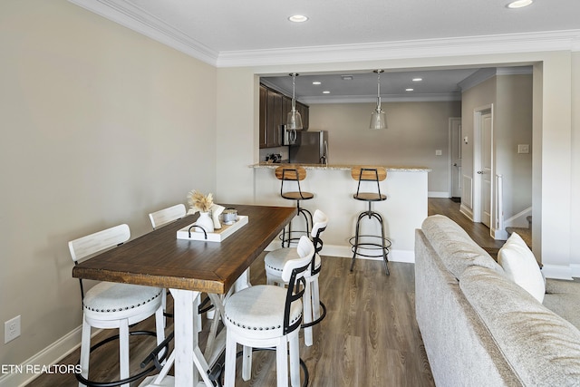 dining area with dark hardwood / wood-style flooring and ornamental molding