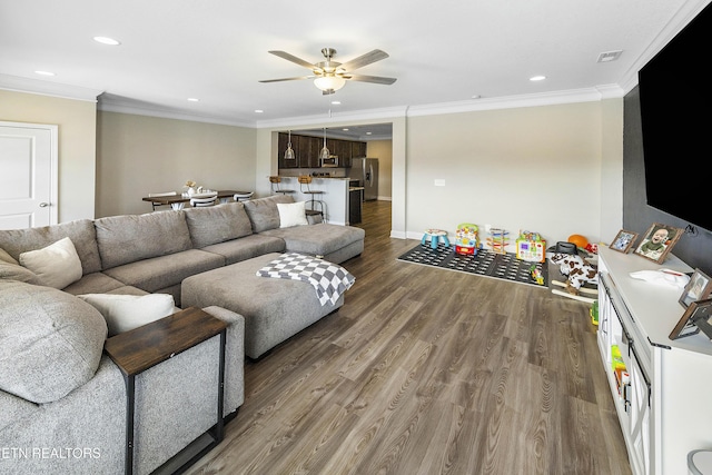 living room featuring ceiling fan, wood-type flooring, and ornamental molding