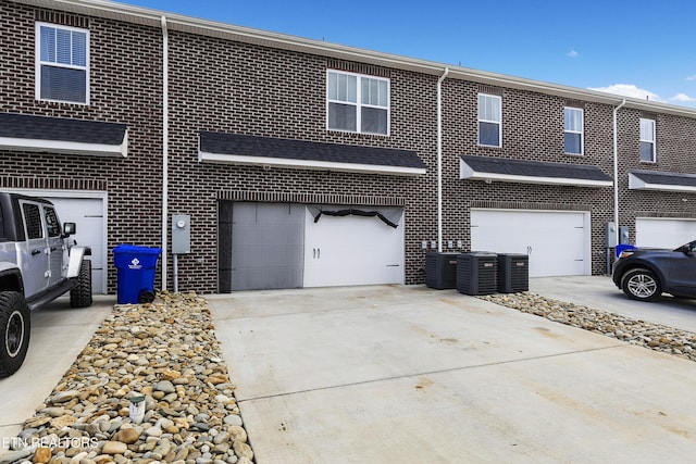 view of front of home featuring cooling unit and a garage