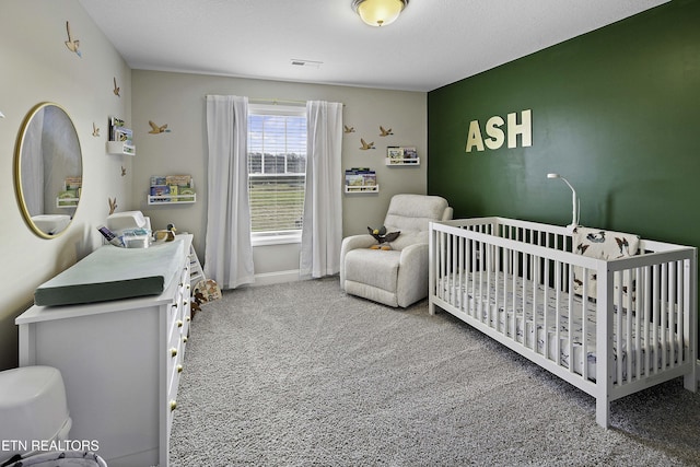 carpeted bedroom with a nursery area