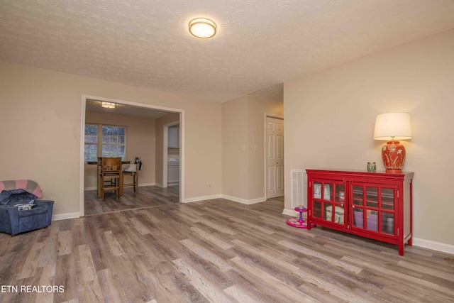 unfurnished room featuring wood-type flooring and a textured ceiling