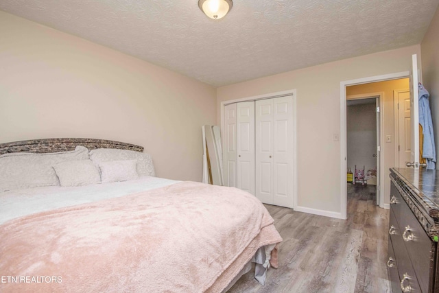 bedroom featuring a textured ceiling, a closet, and light wood-type flooring