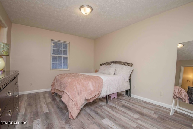 bedroom featuring wood-type flooring and a textured ceiling