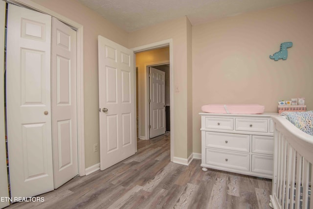 unfurnished bedroom with a closet, a textured ceiling, and light hardwood / wood-style flooring