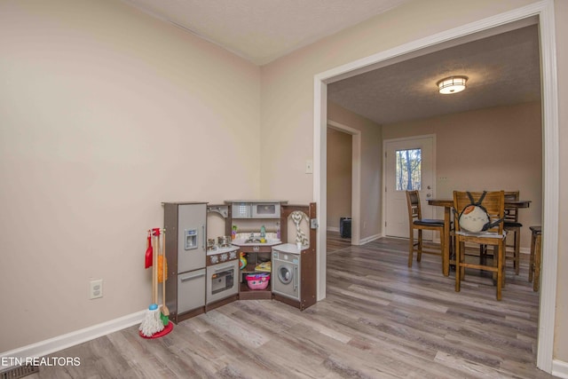 rec room with hardwood / wood-style flooring and a textured ceiling