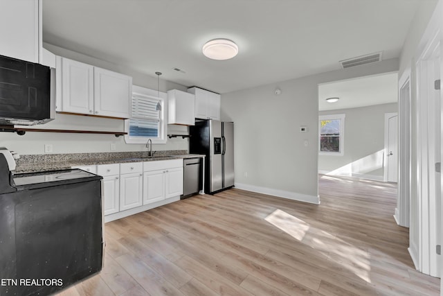 kitchen featuring white cabinets, pendant lighting, light hardwood / wood-style floors, and appliances with stainless steel finishes