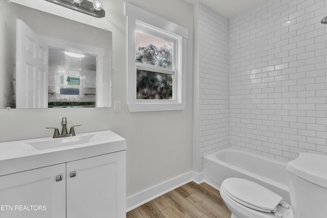 full bathroom with wood-type flooring, vanity, toilet, and tiled shower / bath combo