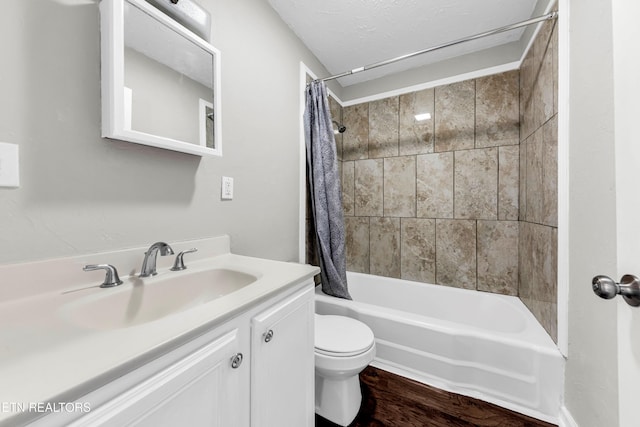 full bathroom featuring vanity, toilet, a textured ceiling, and shower / tub combo